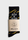 Black cotton socks with yellow zigzag pattern, designed for comfort and support, packaged in branded wrap.