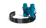 Teal binoculars with a woven fabric strap displaying colorful geometric patterns, designed for comfortable carrying.