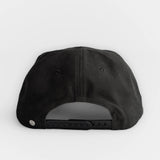 Black cotton twill hat with adjustable snapback, shown from the back.