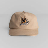 Beige cotton hat with adjustable strap and embroidered bird/banner detail on the front. Suitable for casual wear.