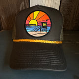 Brown trucker hat with sunset beach patch, lifeguard tower, and golden braided rope accent