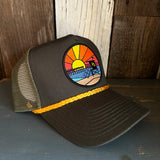 Trucker hat with mesh back, sunset beach patch, lifeguard tower and yellow rope accent