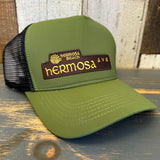 Evergreen vintage trucker hat with moisture-wicking band displayed on rustic wood background.