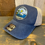Blue mesh trucker hat with Hermosa Beach California beach patch on wooden surface
