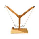 Wooden hook and ring game with two strings, metal rings, and a central hook for head-to-head play.