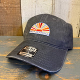 Charcoal grey 6-panel dad hat made of fabric rests on a wooden surface.
