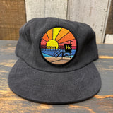 Black cotton hat with embroidered patch featuring a sunset, pier, and Hermosa Beach lifeguard tower.