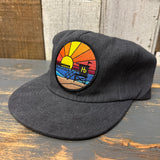 Vintage black baseball cap on a wooden surface, made from cotton, suitable for casual outdoor wear.