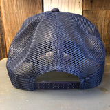 Navy mesh trucker hat with red braid, shown from the back on wood surface.