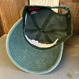 Dark green 6-panel cotton dad hat flipped to reveal red OTTO label on a wooden surface.