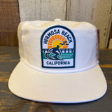 White retro snapback hat made of nylon/cotton blend, featuring a surfer sunset patch. Ideal for casual beachwear.