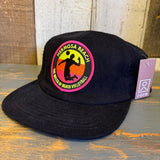Black 6-panel micro cord beach volleyball hat displayed on a wooden surface.