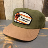 Two-tone Cactus/Dune workhorse hat with palm, sunset, and bird patch; durable fabric suitable for everyday wear.