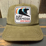 Olive green corduroy surf cap with a surfer patch and colorful stripes, suitable for beach or casual wear.