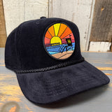 Black corduroy baseball cap with a sunset patch, designed for casual wear.