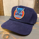 Navy corduroy volleyball cap with patch detail, displayed on a wooden surface.