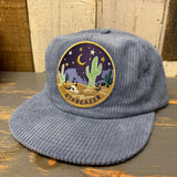Slate blue corduroy field trip hat with desert patch and adjustable strap, made for outdoor wear.