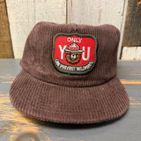 Java brown corduroy hat resting on rustic wood surface, designed for casual outdoor wear.