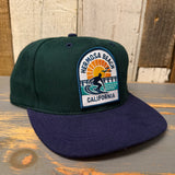 Dark green and navy baseball cap with 1 to 3 FEET HIGH & RISING text; cotton material, ideal for casual wear.