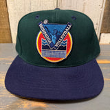 Dark green and navy volleyball cap with signature patch, suitable for beach sports.