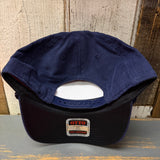 Navy blue corduroy baseball cap shown upside down, highlighting its adjustable strap and brim label.