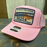 Pink high-crown trucker hat with mesh panels, pier patch, and 90254 embroidery; casual beachwear accessory.