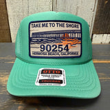 Cactus green trucker hat with mesh panels and adjustable snapback, suitable for outdoor or casual wear.