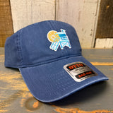 Navy cotton dad hat with lifeguard tower patch, six panels, sticker on brim, displayed on wooden surface.
