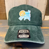 Dark green cotton dad hat with lifeguard tower patch, displayed on a wooden surface.