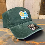 Dark green 6-panel cotton dad hat with a lifeguard tower patch, displayed on a rustic wood surface.