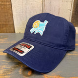 Navy cotton dad hat with lifeguard tower embroidery, displayed on a wooden surface. Suitable for casual outdoor wear.