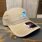 Khaki cotton 6-panel dad hat featuring a colorful lifeguard tower logo, displayed on a wooden surface.