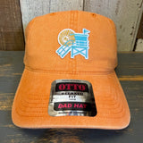 Pumpkin orange dad hat with a logo and 'OTTO' label on a wooden surface
