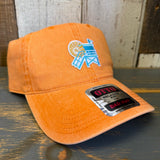 Pumpkin orange cap with a logo and text on a wooden surface.