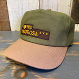 Cap with cactus green and dune brown colors with 'Hermosa Beach Hermosa Ave' patch on a wooden surface