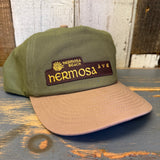 Cactus green and dune brown cap with 'Hermosa Beach Ave' logo on a wooden surface