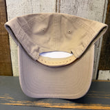 Upside-down Khaki baseball cap on a wooden surface with a rustic background.