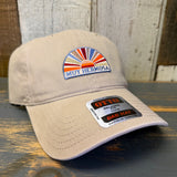 Khaki cap with a colorful logo and brand label on a wooden surface