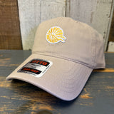 Khaki cap with a logo and label on a wooden surface.