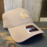 Khaki cap with a Hb logo and label on a wooden surface.