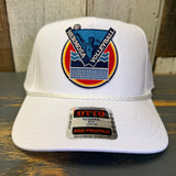 White cap with Hermosa Volleyball logo on a wooden surface.