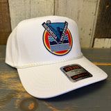 White cap with a colorful Hermosa Volleyball logo on a wooden surface.