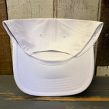 Upside-down white cap on a wooden surface with a wooden background.