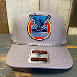 Gray cap with Hermosa Volleyball logo on a wooden surface.