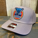 Gray cap with a colorful HV logo and 'OTTO' label on a wooden surface