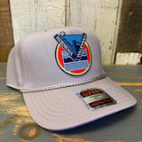 Sideview of gray cap with Hermosa Volleyball logo on a wooden surface.