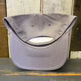 Upside-down gray cap on a wooden surface with a rustic background.