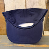 Navy blue cap on a wooden surface with a wooden wall background