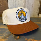 White cap with brown bill featuring a 'South Bay Surf California' logo on a wooden surface.