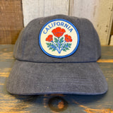 Gray cap with California poppy design on a wooden surface.